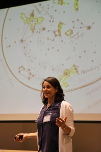 Annette Lee stands in front of a star map projection